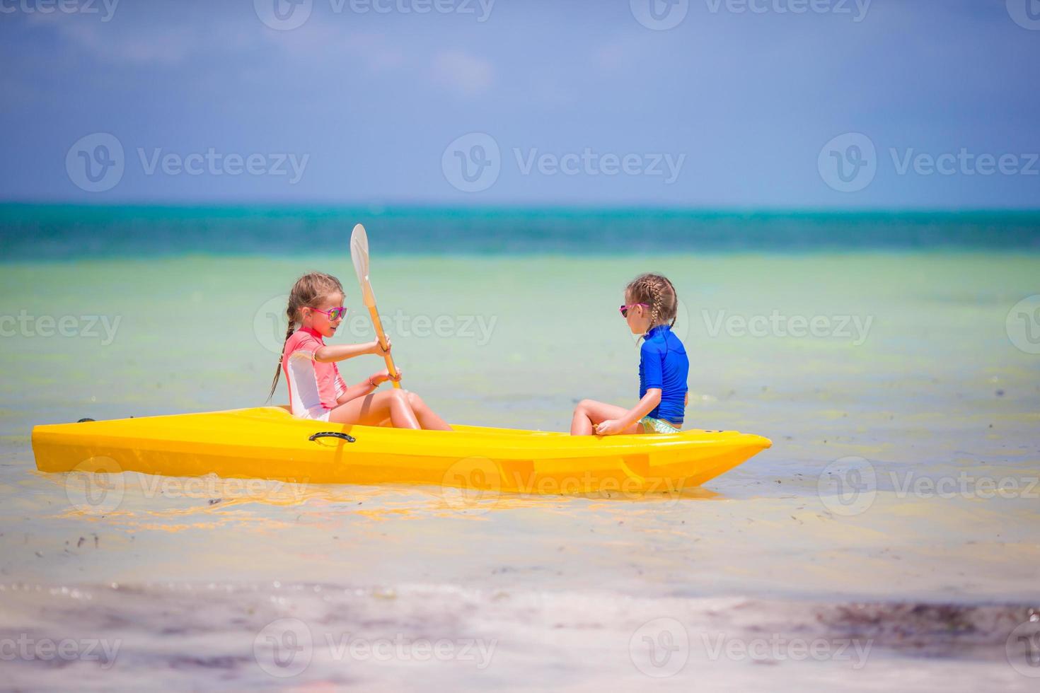 kleine entzückende Mädchen, die Kajakfahren im Meer genießen foto