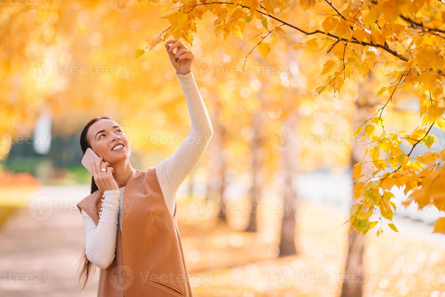 Herbstkonzept - schöne Frau trinkt Kaffee im Herbstpark unter Herbstlaub foto