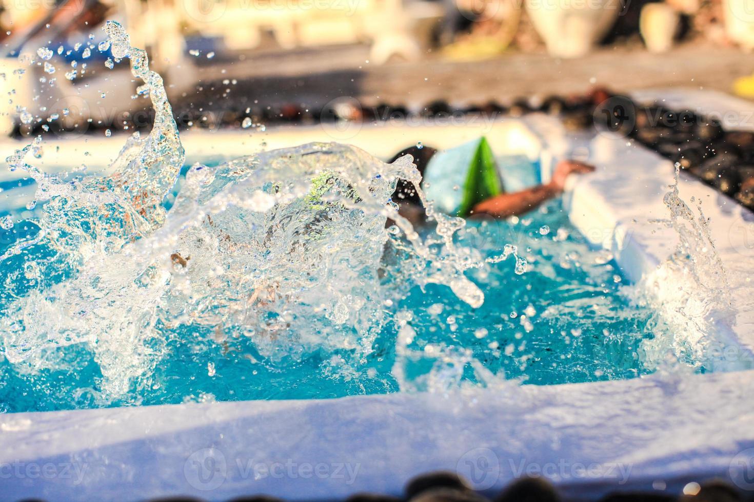 kleines Mädchen spritzt im Schwimmbad foto