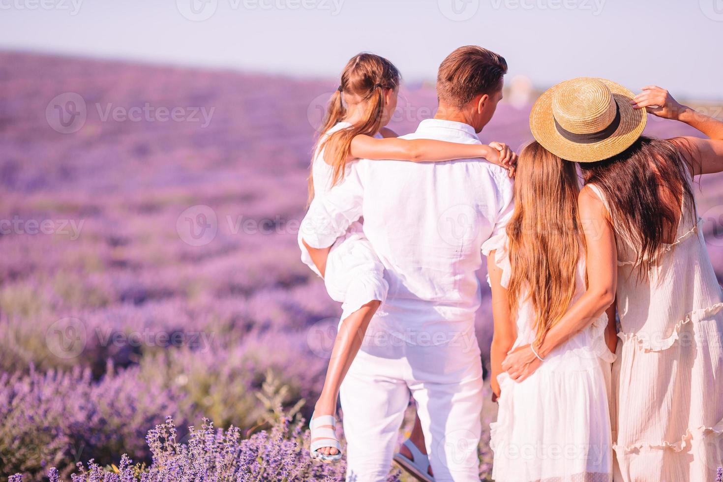 Familie im Lavendelblumenfeld bei Sonnenuntergang im weißen Kleid und im Hut foto