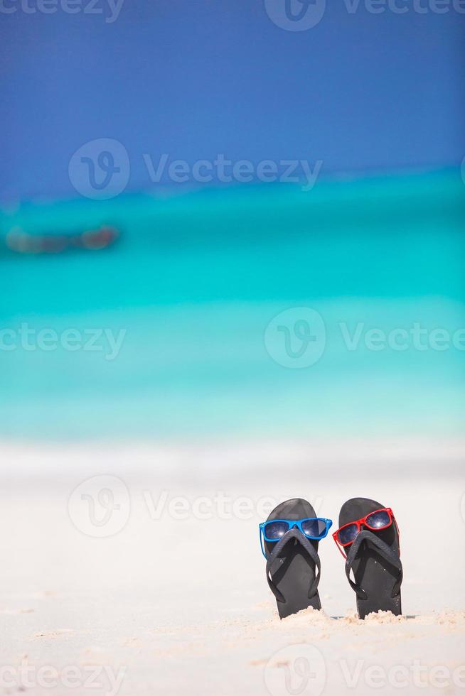 Sommer schwarze Flip-Flops mit Sonnenbrille Hintergrund türkisfarbenes Meer foto