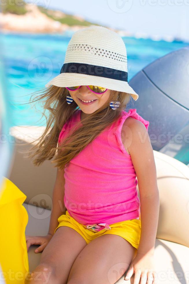 süßes kleines Mädchen, das Segeln auf dem Boot im offenen Meer genießt foto
