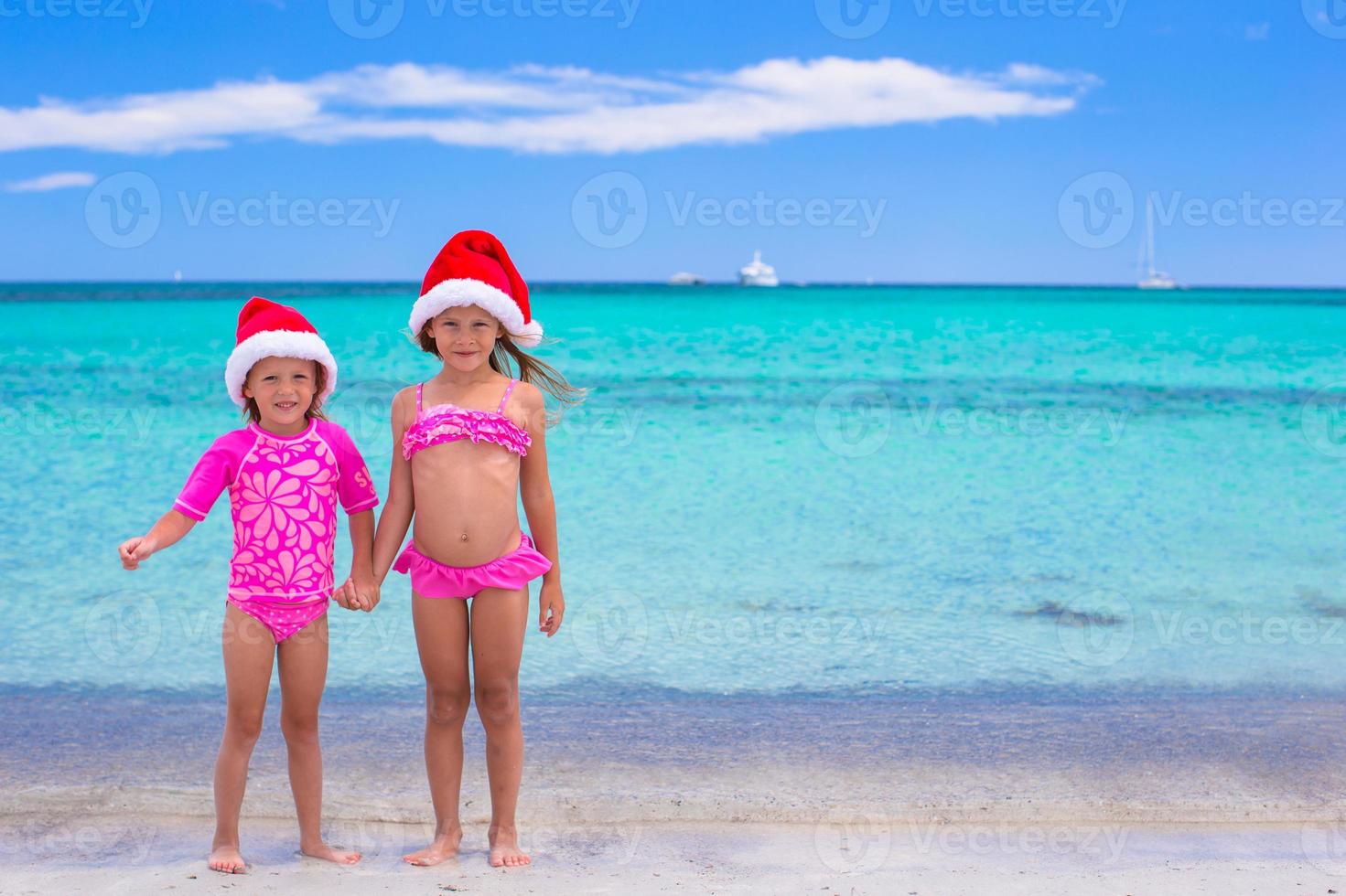 kleine Mädchen in Weihnachtsmützen während der Sommerferien foto