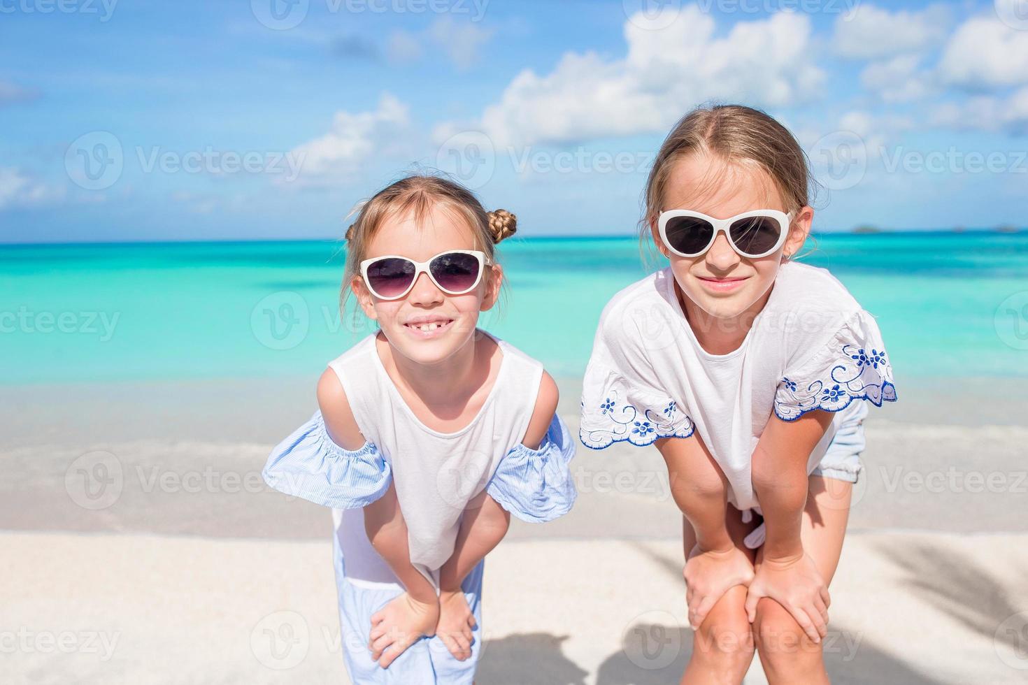 Porträt von zwei schönen Kindern, die den Kamerahintergrund der wunderschönen Natur des blauen Himmels und des türkisfarbenen Meeres betrachten foto