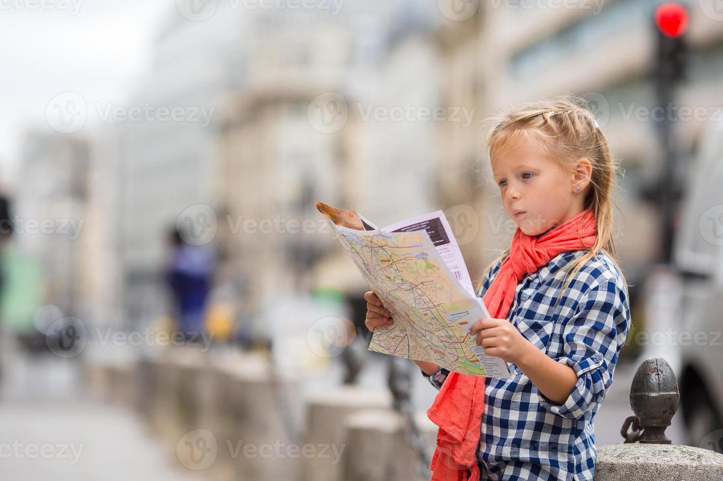 entzückendes kleines Mädchen mit Karte der europäischen Stadt im Freien foto