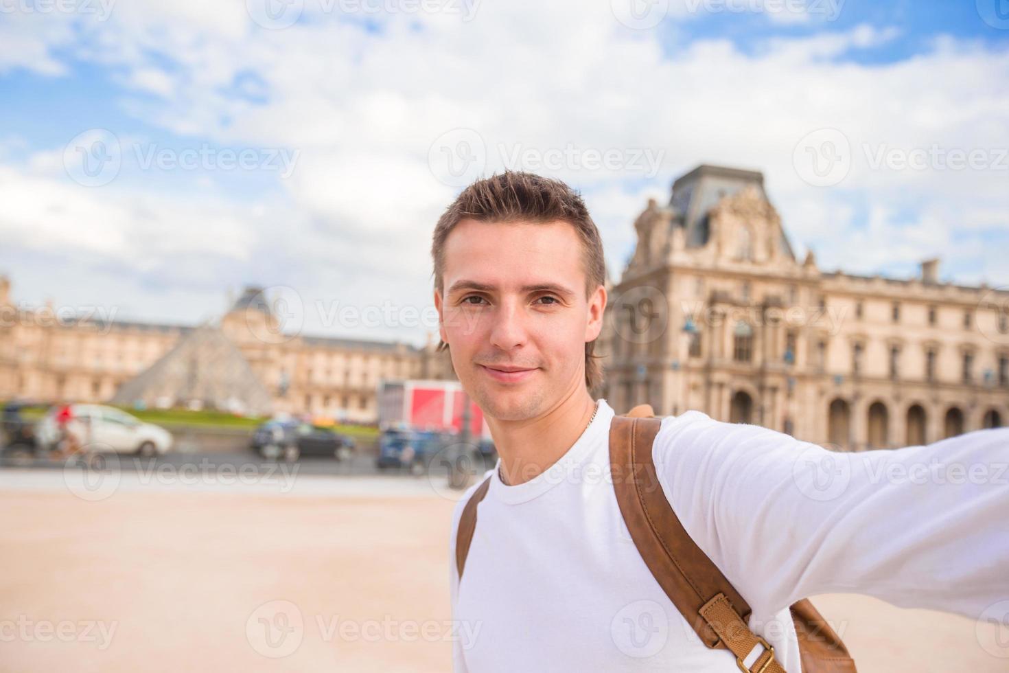 glücklicher junger mann, der ein selfie-foto in paris, frankreich macht foto