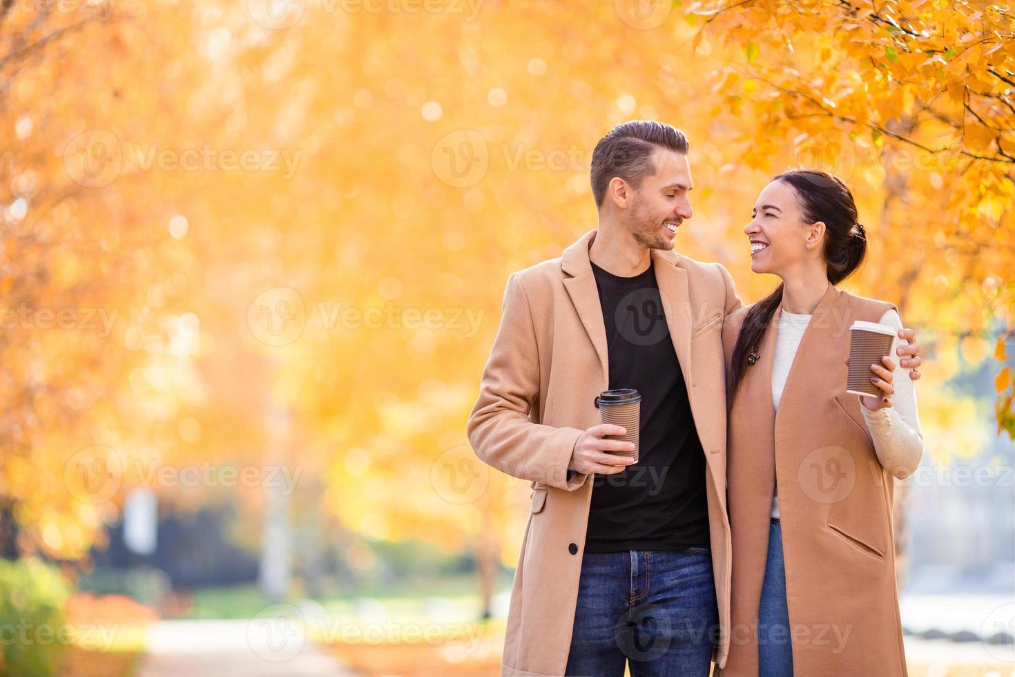 glückliche Familie, die an einem sonnigen Herbsttag im Herbstpark spazieren geht foto