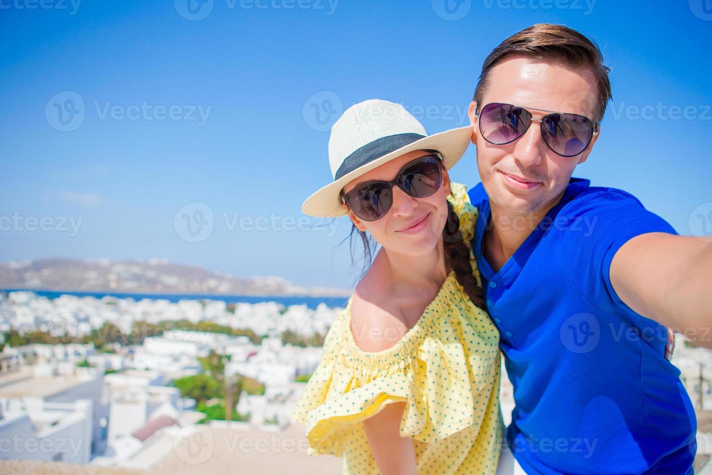 Selfie-Paar beim Fotografieren auf der Insel Mykonos, Kykladen. touristen, die in den sommerferien reisefotos mit dem smartphone machen. foto