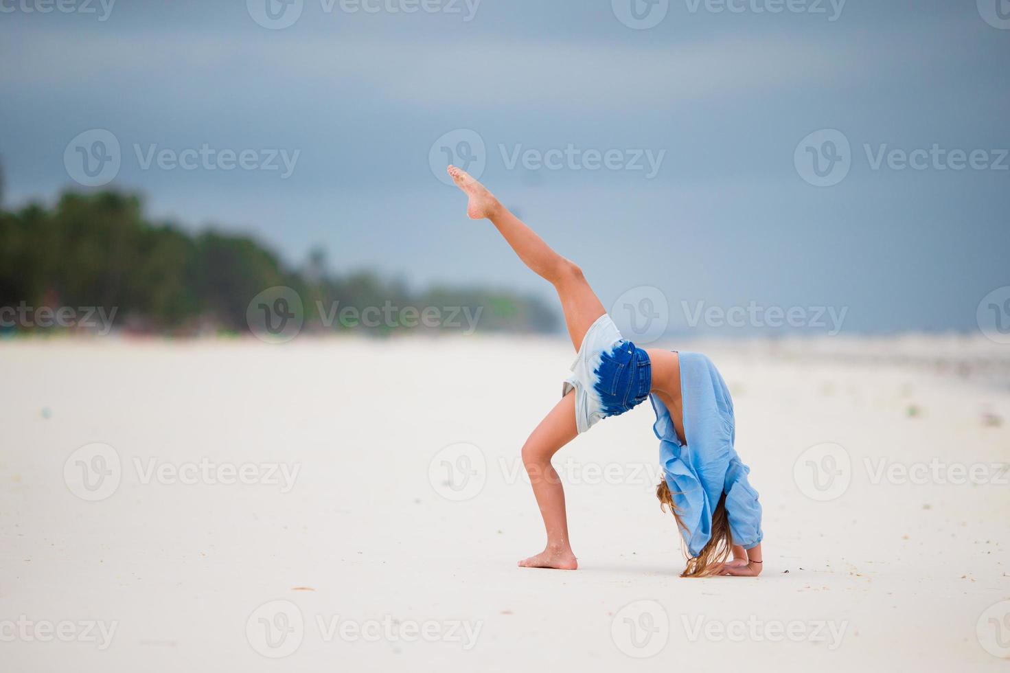 aktives kleines Mädchen im Strandurlaub, das Spaß hat foto
