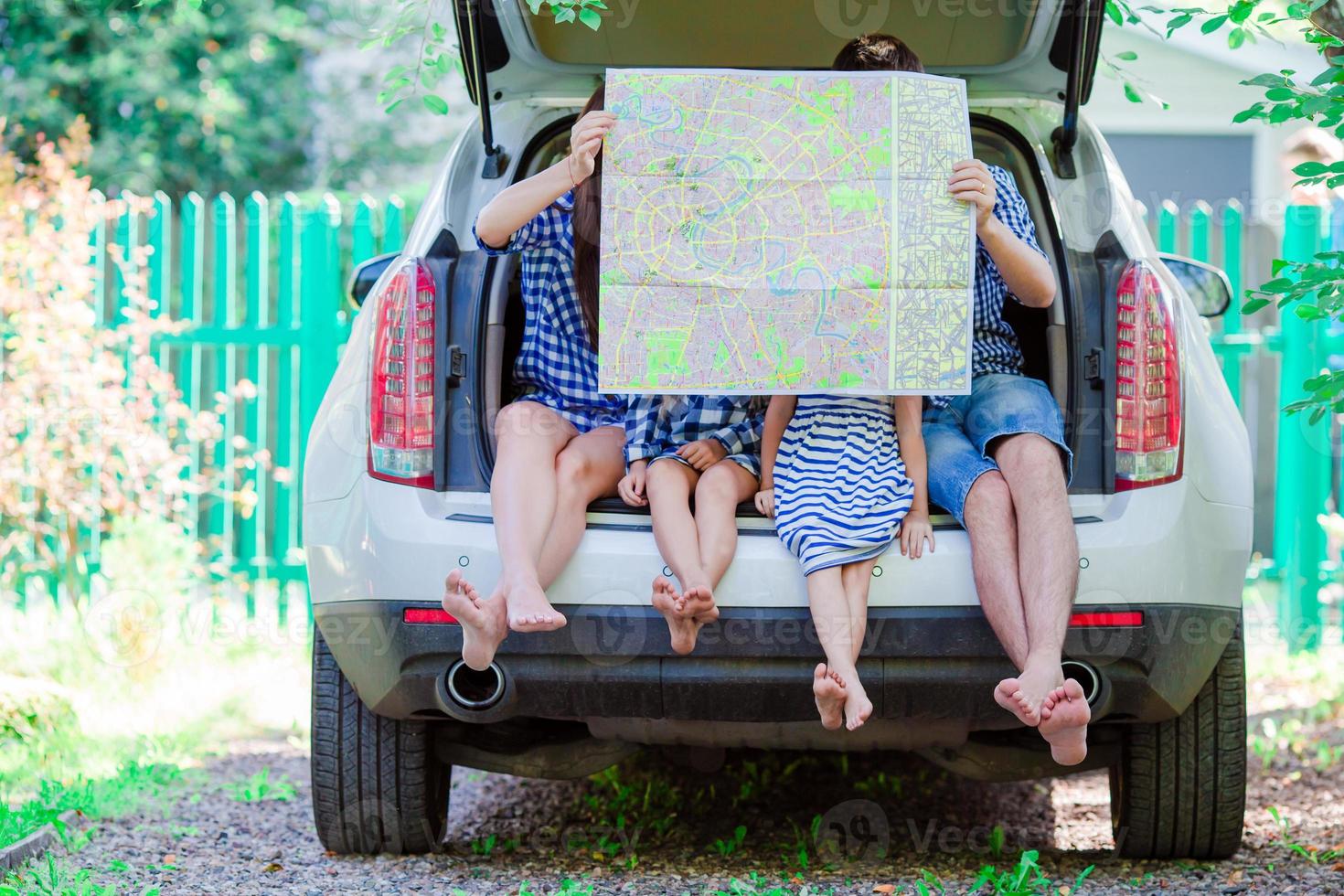 familie mit zwei kindern, die sich die karte ansehen, während sie mit dem auto unterwegs sind foto