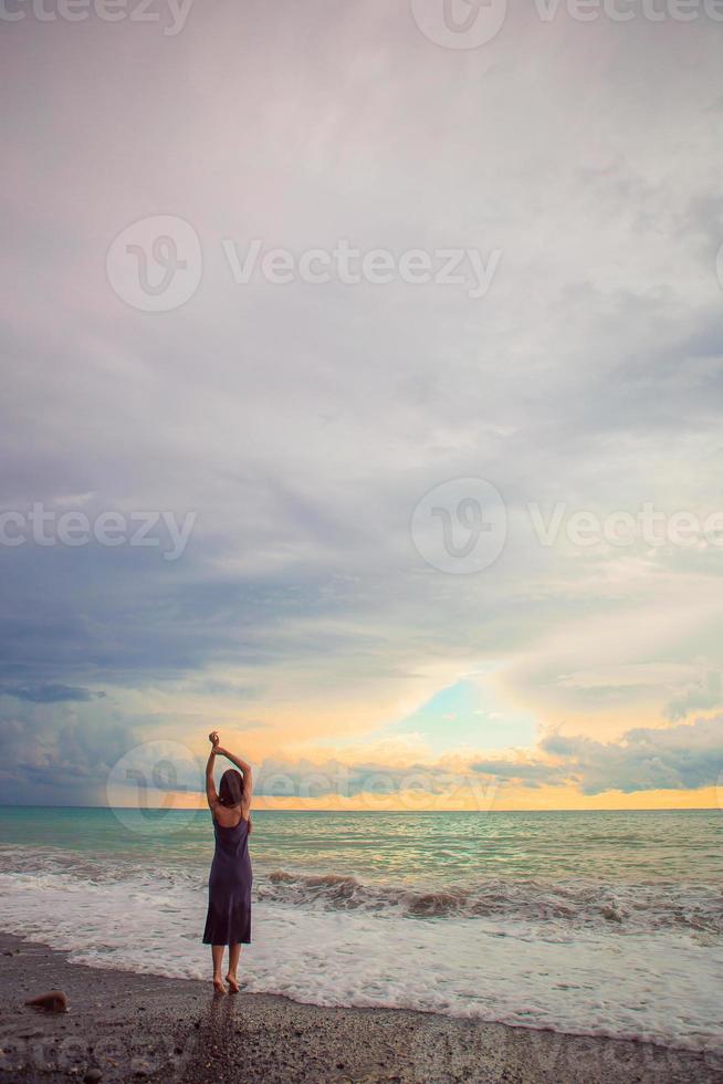 Frau, die am Strand liegt und die Sommerferien mit Blick auf das Meer genießt foto