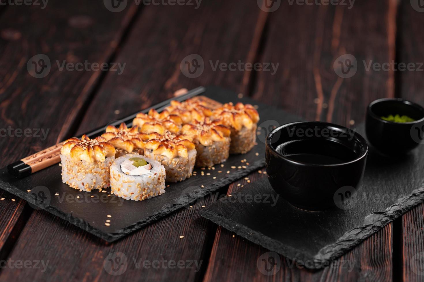 Sushi-Rolle Philadelphia mit Hühnchen-Avocado und Frischkäse auf schwarzem Hintergrund, Nahaufnahme. Sushi-Menü. japanisches lebensmittelkonzept foto