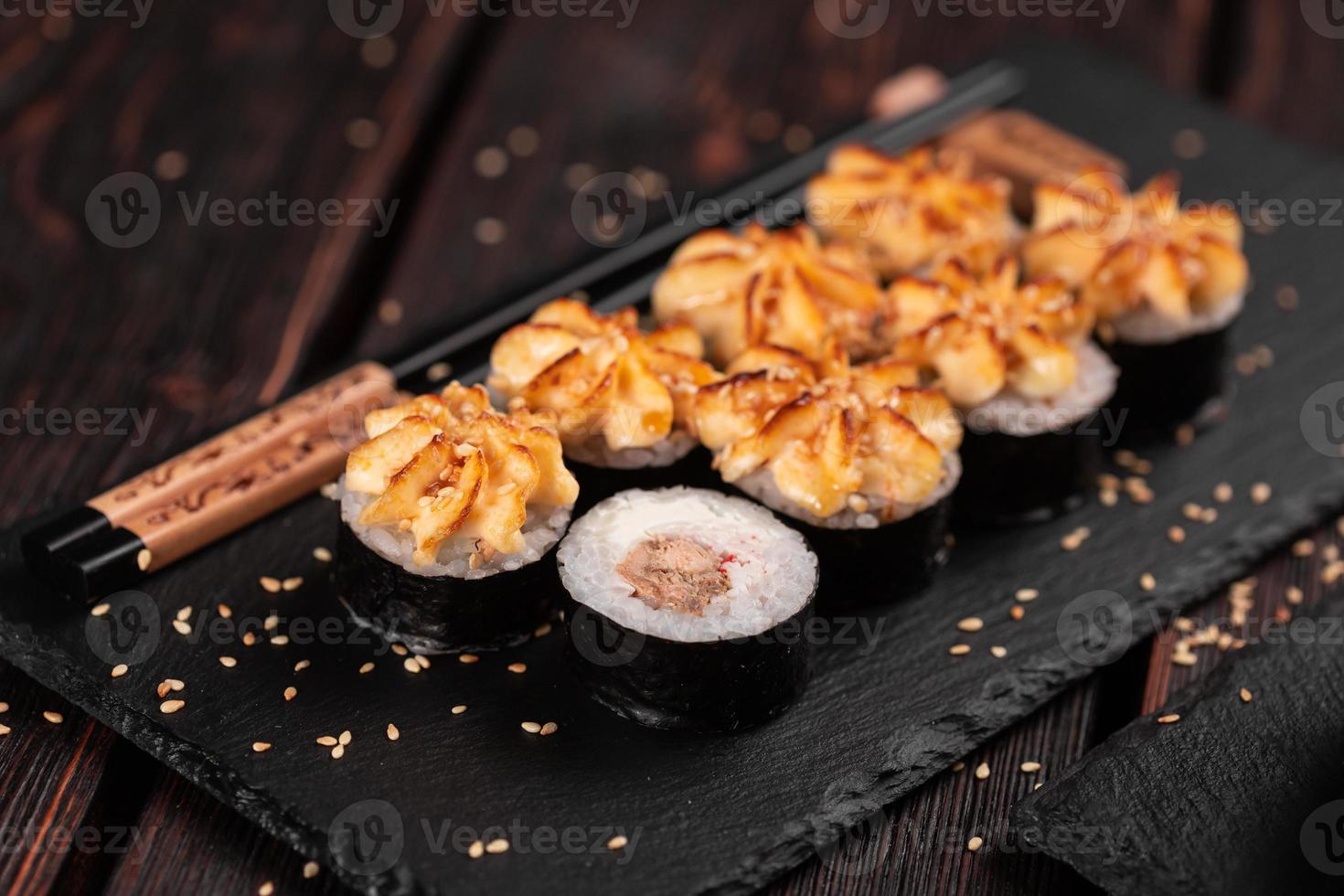 Maki-Sushi-Rolle mit Aal serviert auf schwarzem Brett Nahaufnahme - japanisches Essen foto