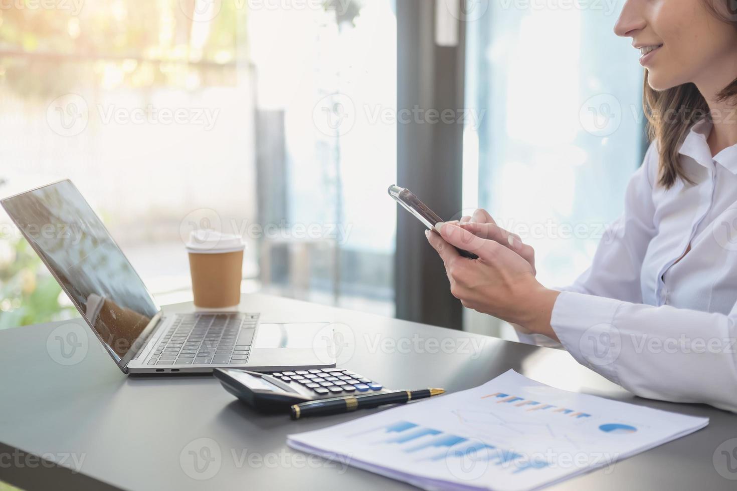 marketing, finanzen, buchhaltung, planung, geschäftsfrauen analysieren unternehmensergebnisse und gewinne mit grafikstatistiken. Verwenden Sie einen Laptop-Computer und einen Taschenrechner, um den Saldo des Unternehmens zu berechnen. foto