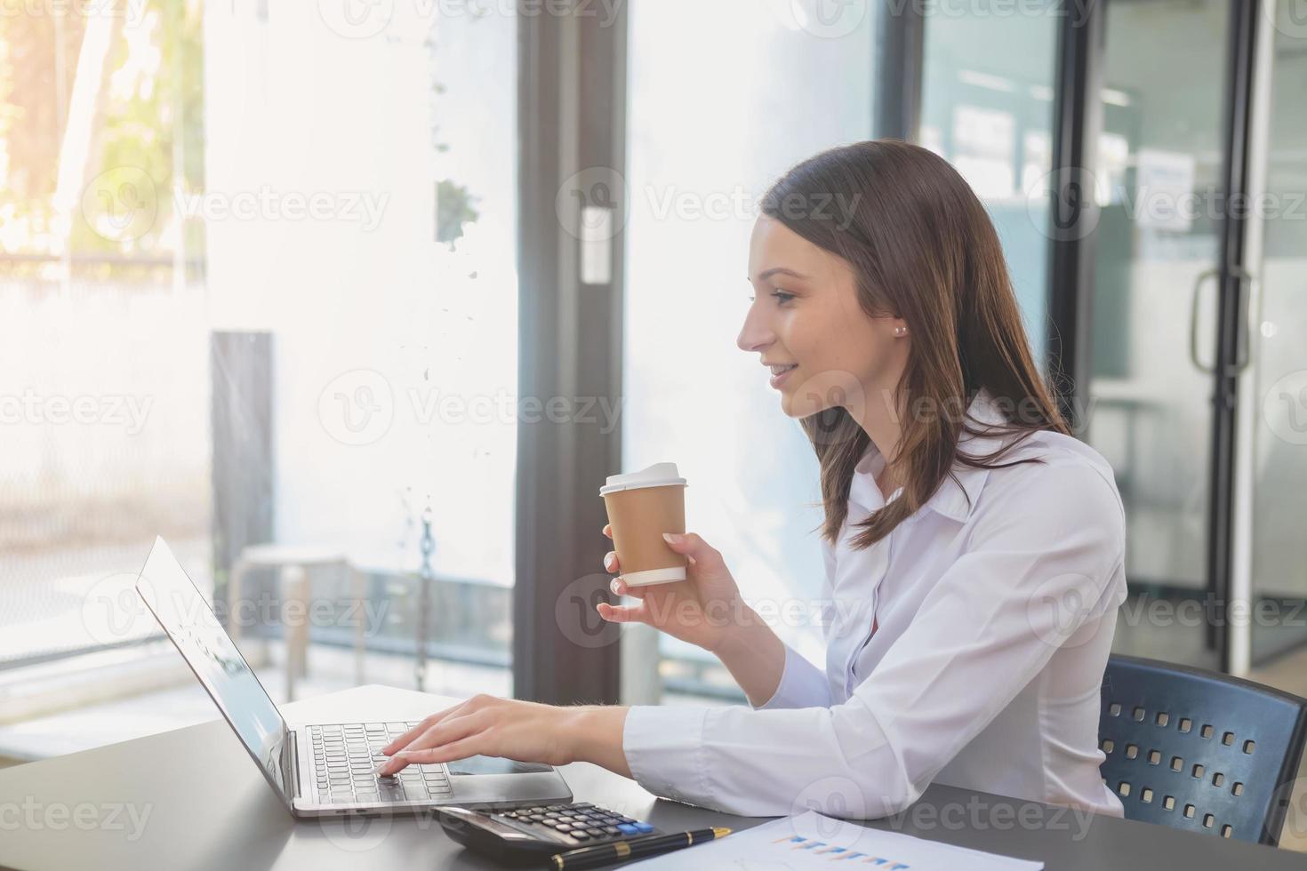 marketing, finanzen, buchhaltung, planung, geschäftsfrauen analysieren unternehmensergebnisse und gewinne mit grafikstatistiken. Verwenden Sie einen Laptop-Computer und einen Taschenrechner, um den Saldo des Unternehmens zu berechnen. foto