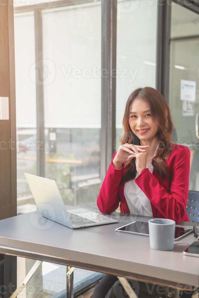 marketing, finanzen, buchhaltung, planung, geschäftsfrauen analysieren unternehmensergebnisse und gewinne mit grafikstatistiken. Verwenden Sie einen Laptop-Computer und einen Taschenrechner, um den Saldo des Unternehmens zu berechnen. foto