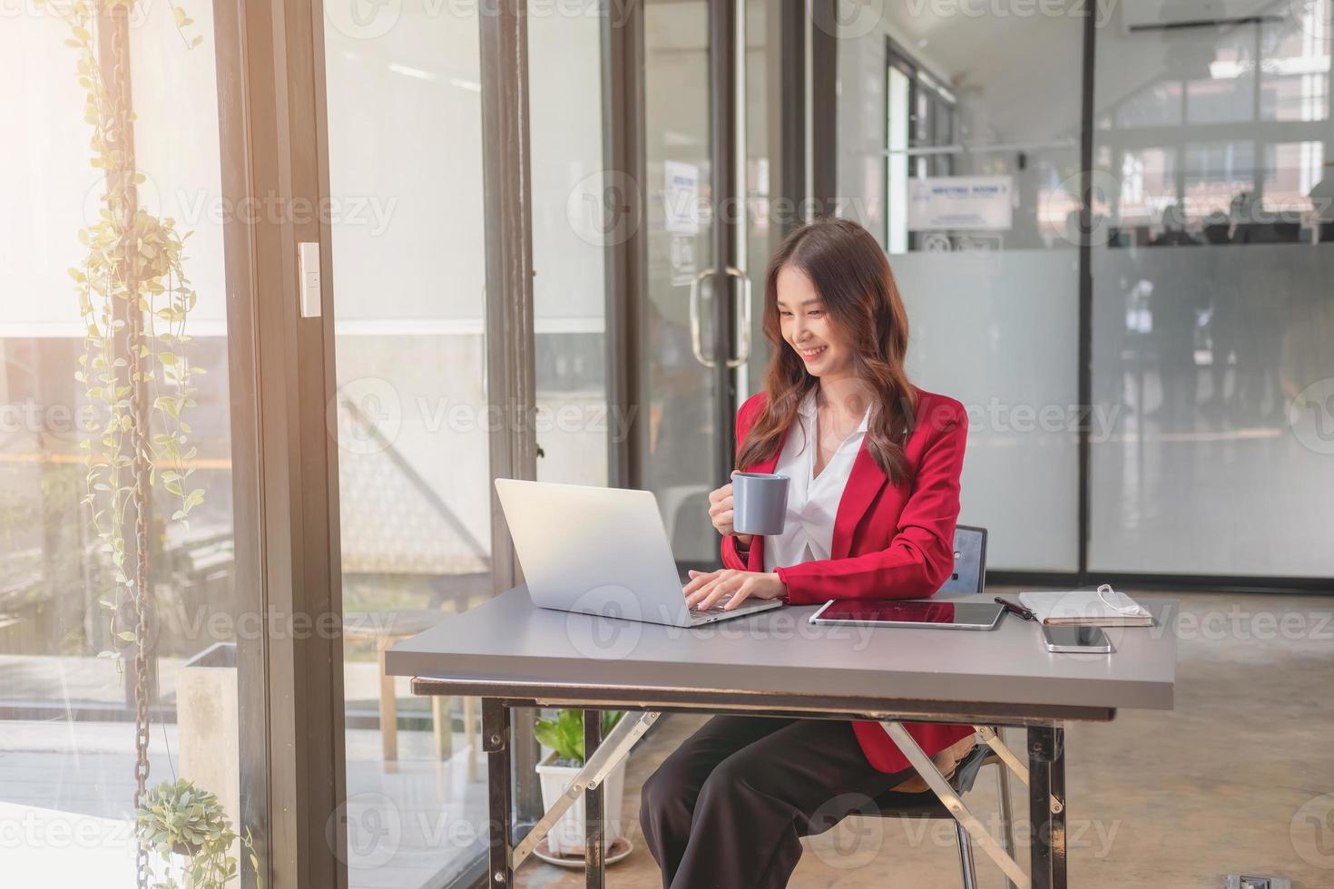 marketing, finanzen, buchhaltung, planung, geschäftsfrauen analysieren unternehmensergebnisse und gewinne mit grafikstatistiken. Verwenden Sie einen Laptop-Computer und einen Taschenrechner, um den Saldo des Unternehmens zu berechnen. foto