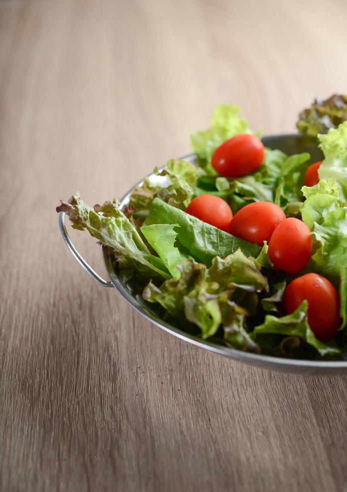 frischer Salat mit Gemüse und Gemüse auf Holztisch foto