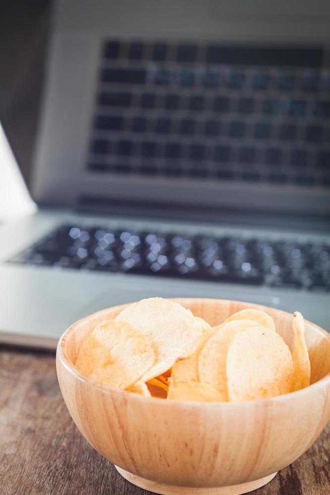 Schüssel Kartoffelchips und ein Laptop foto