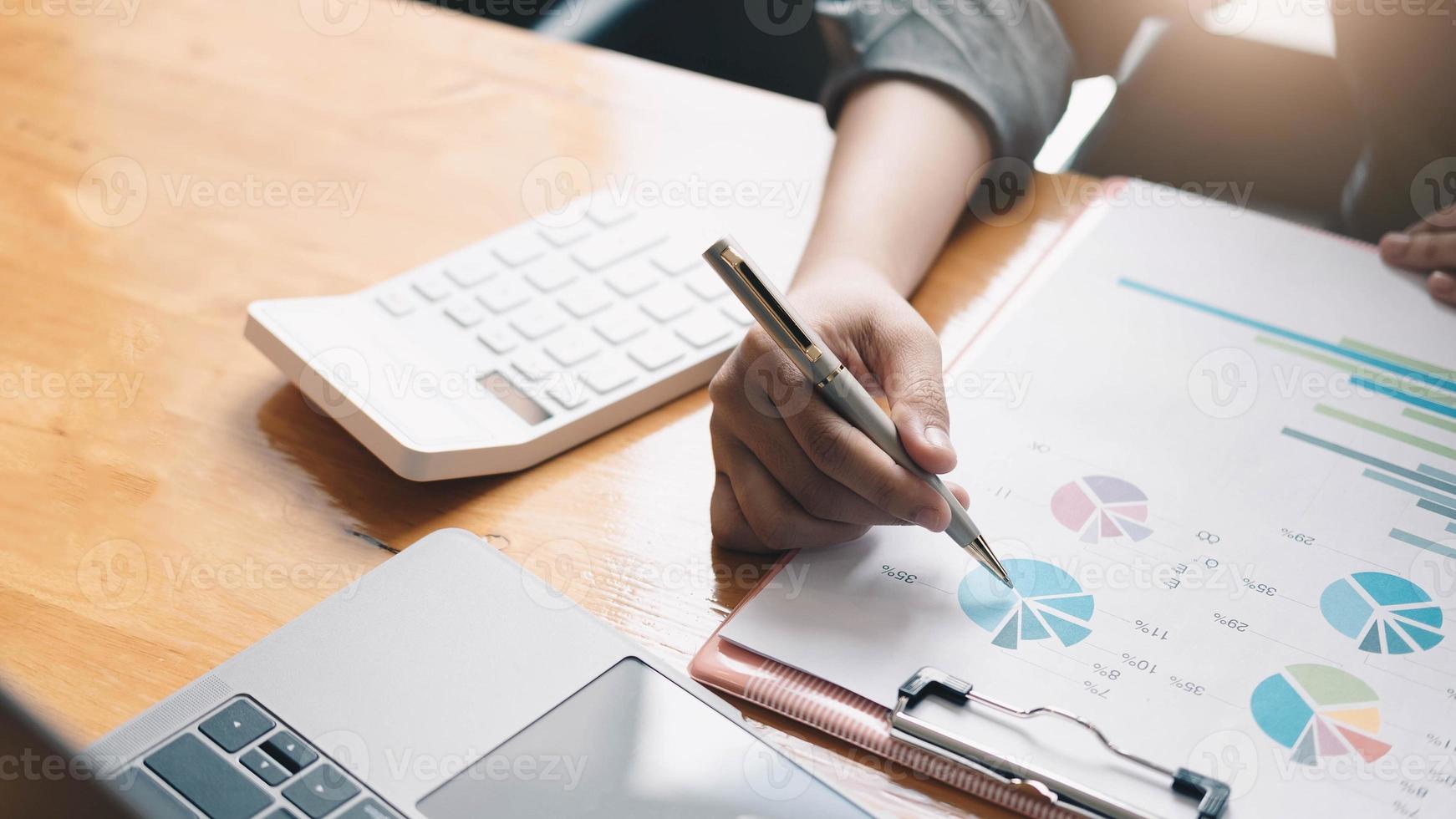 Geschäftsmann, der mit Dokumentengraphen am Schreibtisch arbeitet foto