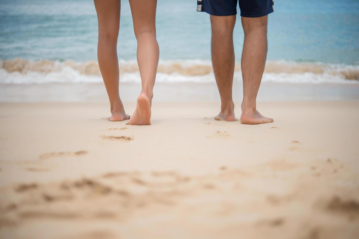 ein paar Liebhaber gehen am Strand spazieren foto