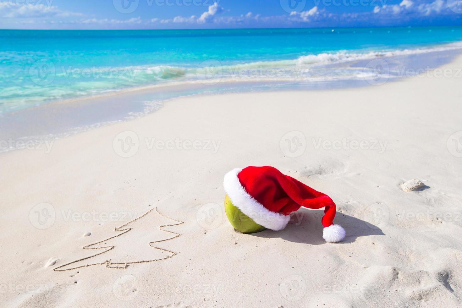 Tannenbaum Zeichnung am Strand weißen Sand mit roten Weihnachtsmütze foto