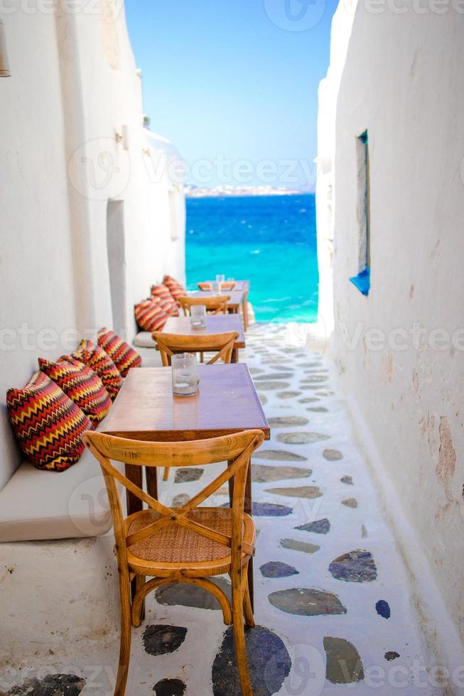 bänke mit kissen in einer typisch griechischen bar auf mykonos mit herrlichem meerblick auf die kykladeninseln foto