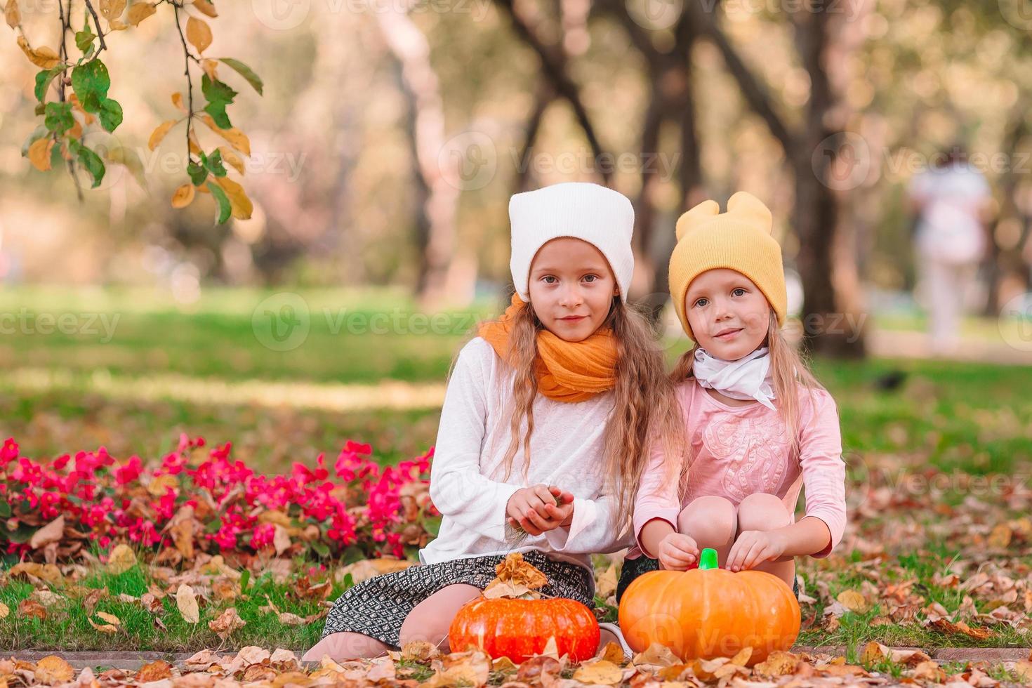 Kleine entzückende Mädchen mit Kürbis im Freien an einem warmen Herbsttag. foto