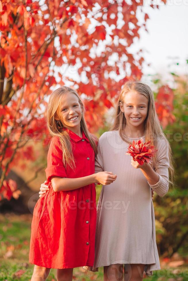 Kleine entzückende Mädchen im Freien am warmen, sonnigen Herbsttag foto