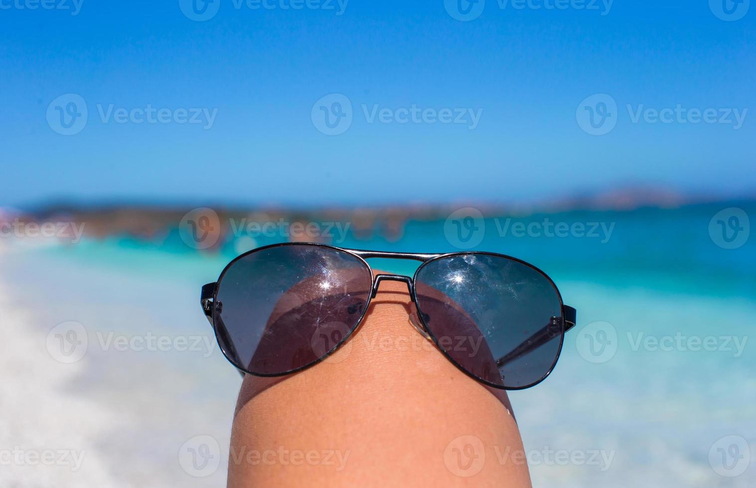 Nahaufnahme von Sonnenbrillen am tropischen Strand foto