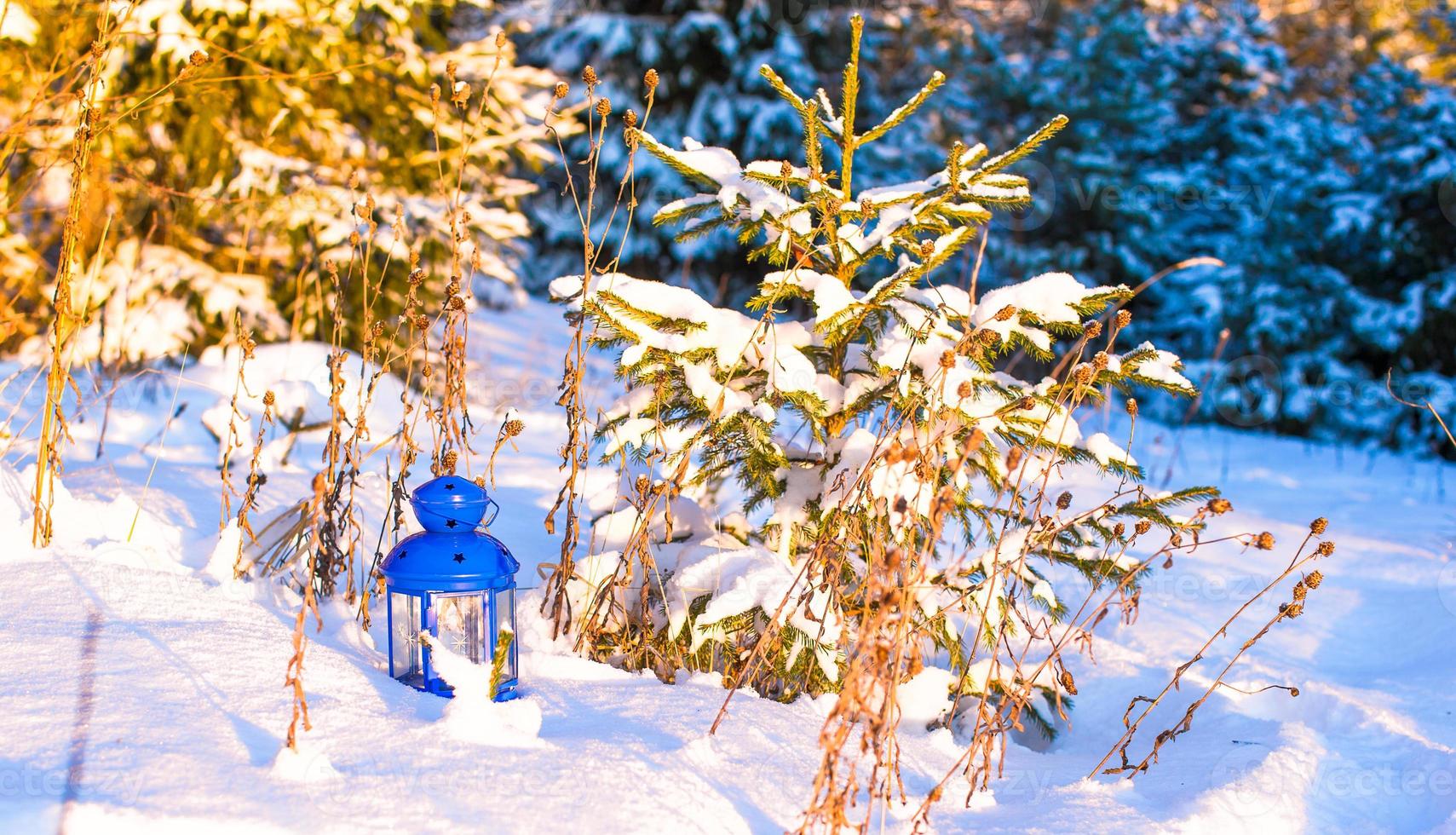 schöne blaue Laterne mit einer Kerze auf weißem Schnee im Freien foto