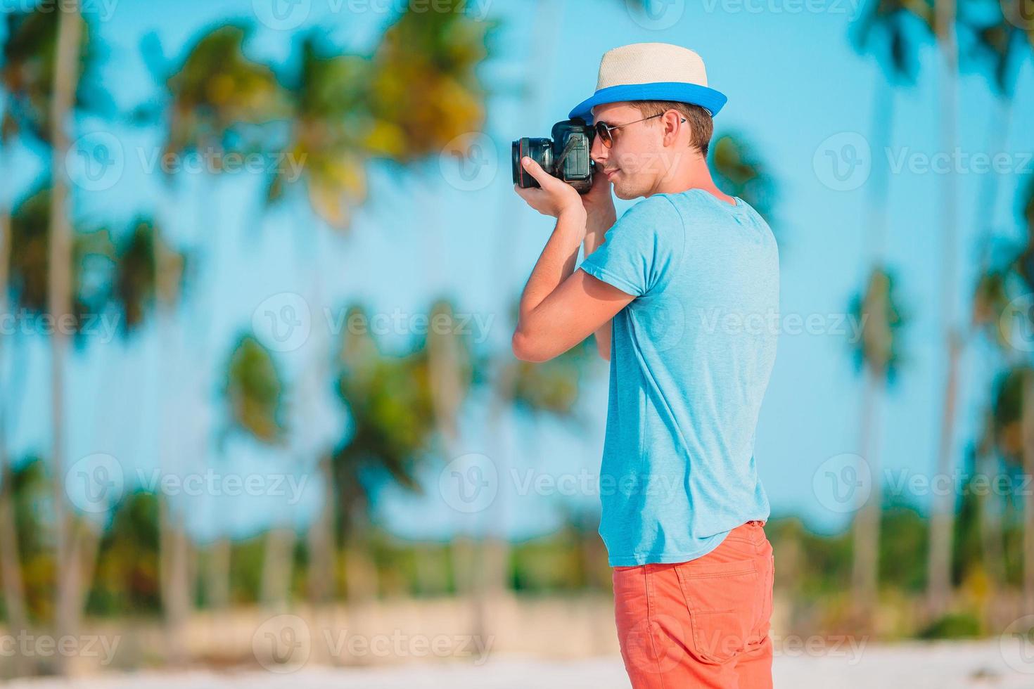 Profil des jungen Mannes fotografiert schöne Meereslandschaft am weißen Sandstrand foto