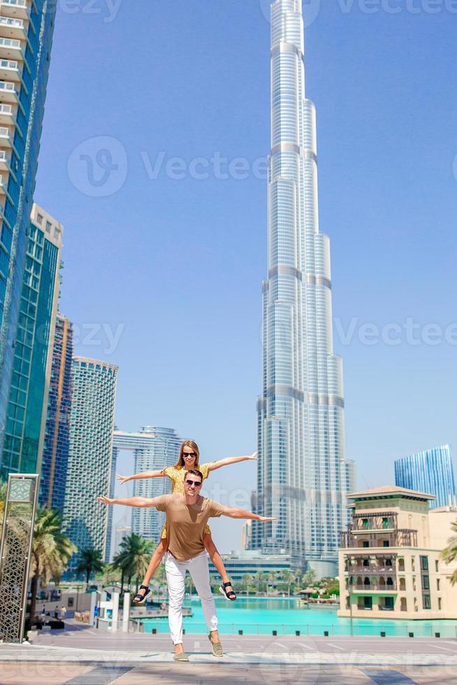 glückliche familie, die in dubai mit wolkenkratzern im hintergrund geht. foto