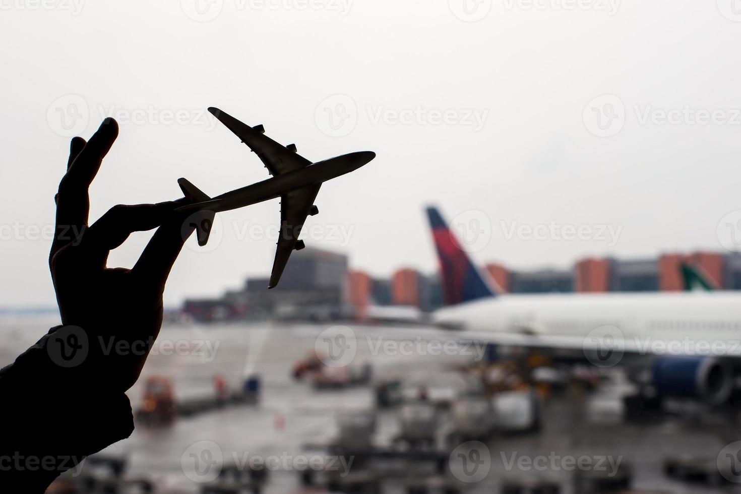 Schattenbild eines kleinen Flugzeugmodells auf Flughafenhintergrund foto