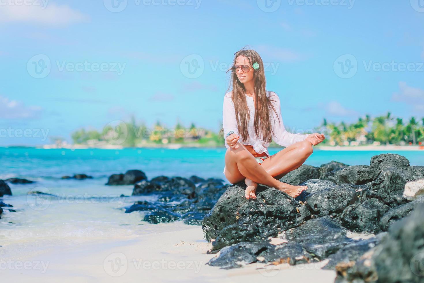 schönes Mädchen in Yoga-Position während der tropischen Ferien foto