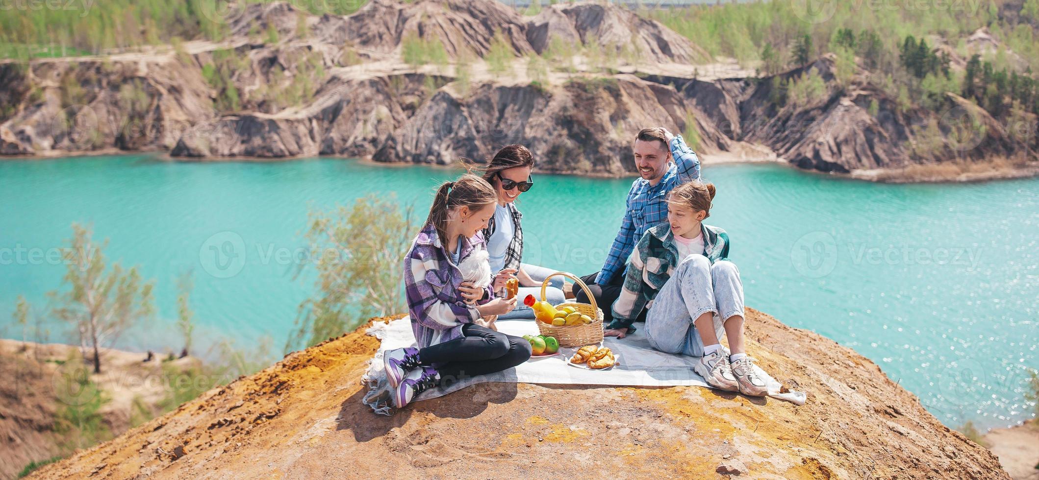 Panorama der jungen Familie beim Picknick nach dem Wandern in den Bergen. schöne Aussicht auf den blauen See foto