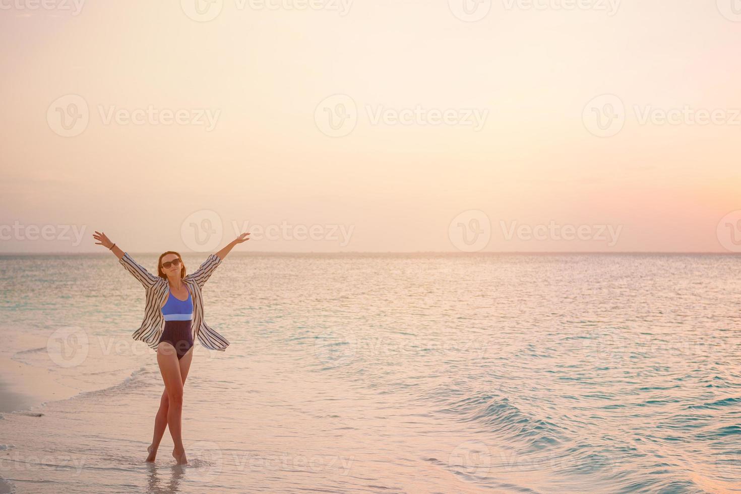 Frau, die am Strand liegt und die Sommerferien mit Blick auf das Meer genießt foto