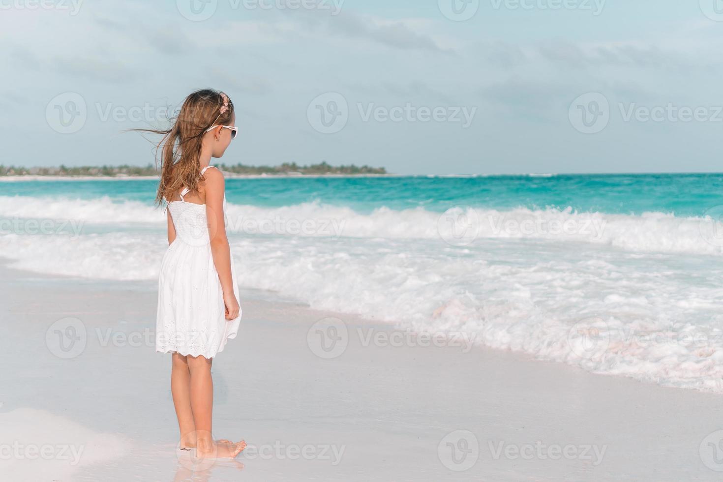 süßes kleines Mädchen am Strand während der Sommerferien foto