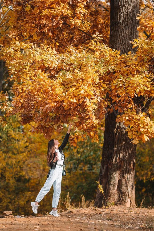 Herbstkonzept - schöne Frau im Herbstpark unter Herbstlaub foto