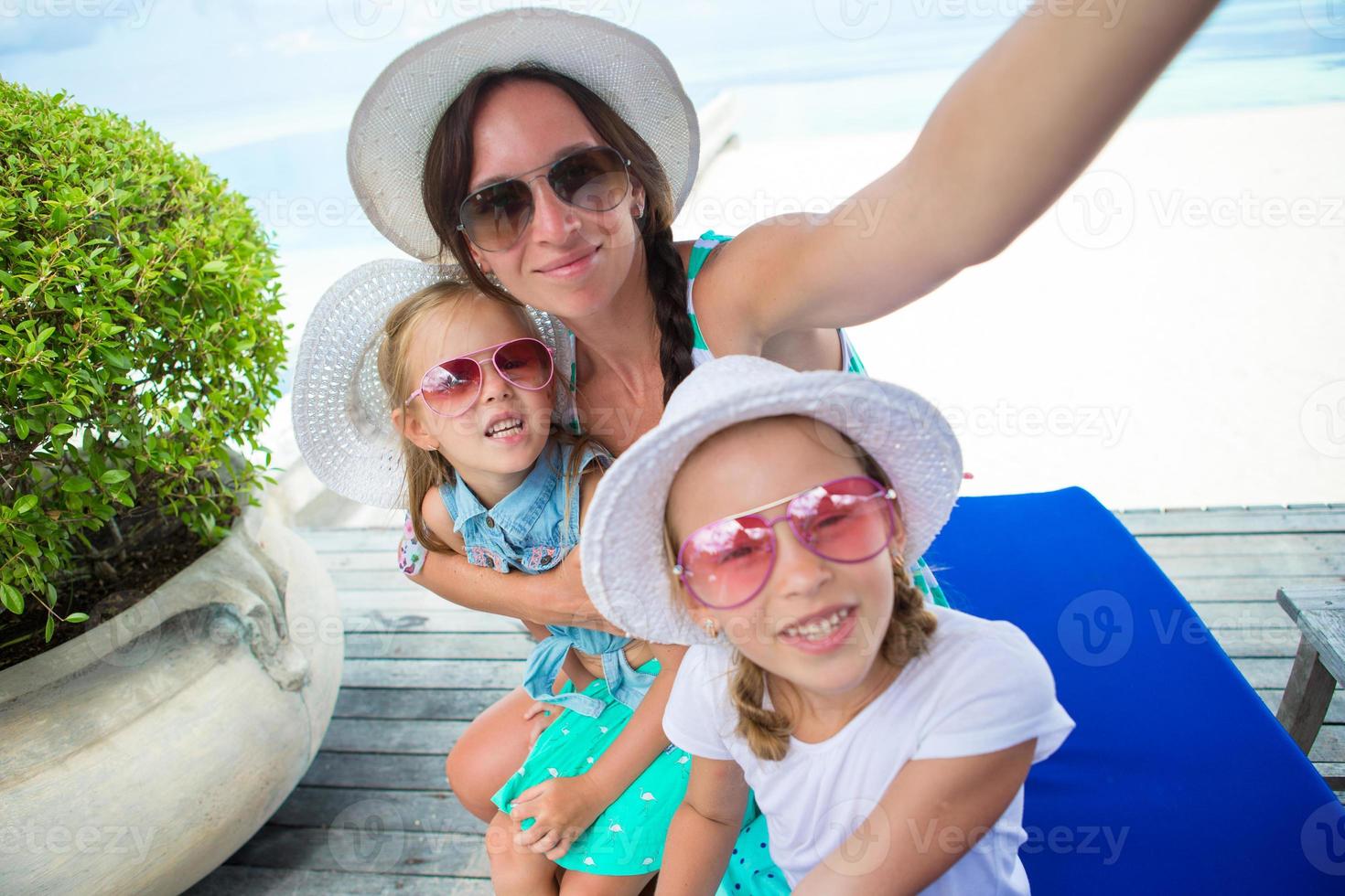 mutter und kleine mädchen, die selfie am tropischen strand machen foto