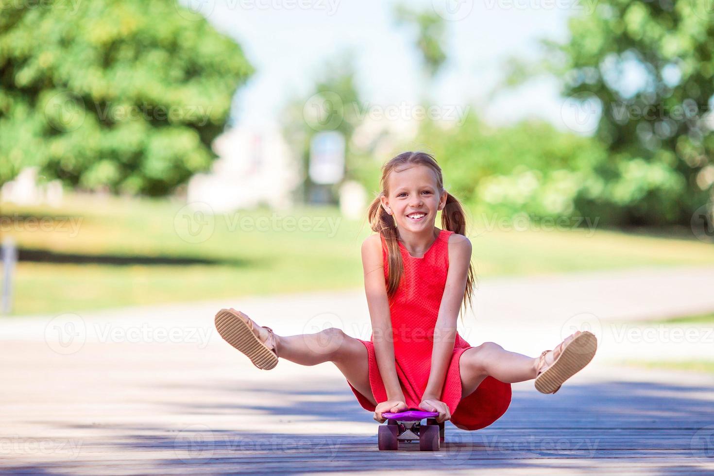 entzückendes kind, das skateboard im sommerpark fährt. foto