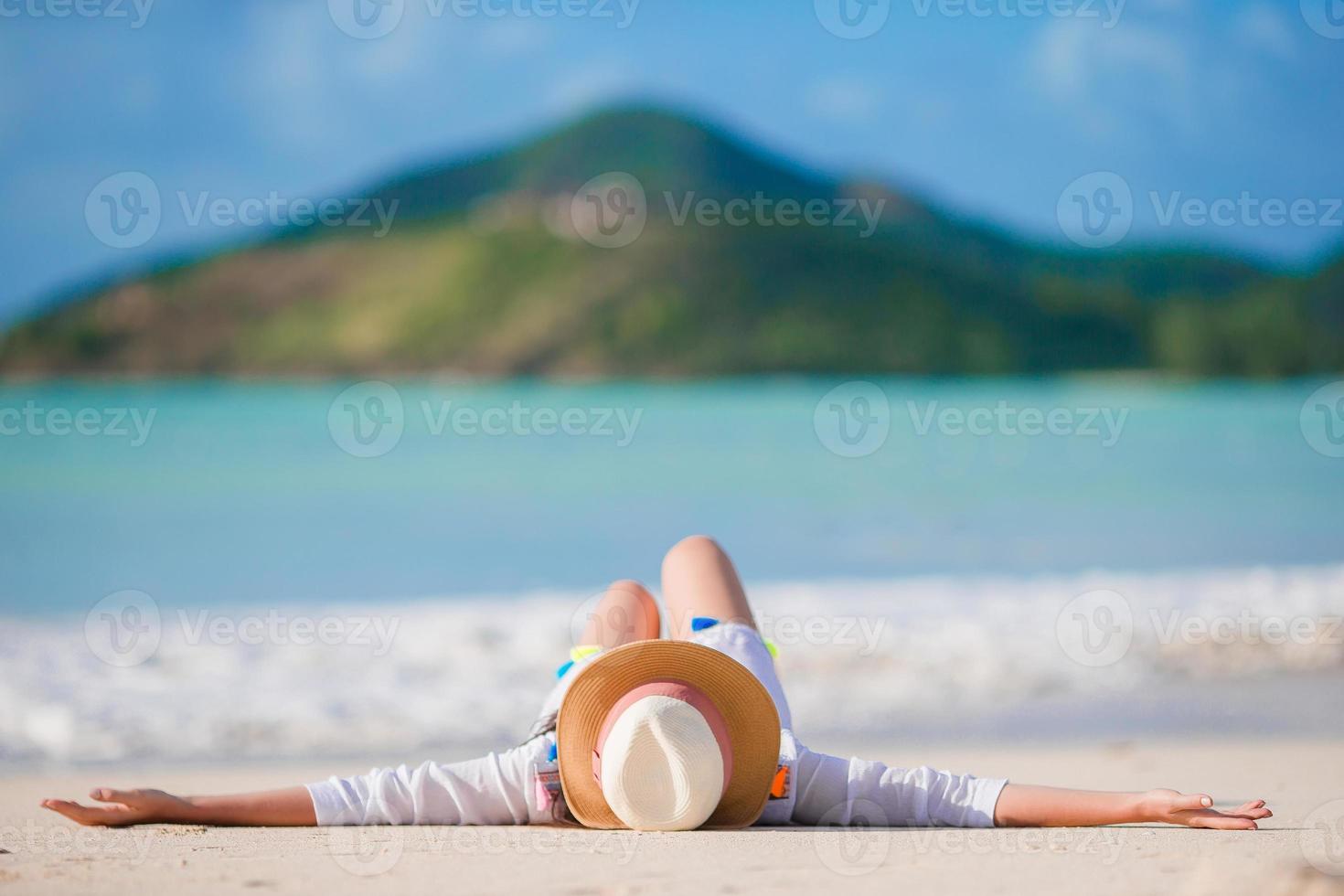 junge frau genießt die sonne beim sonnenbaden am perfekten türkisfarbenen ozean foto