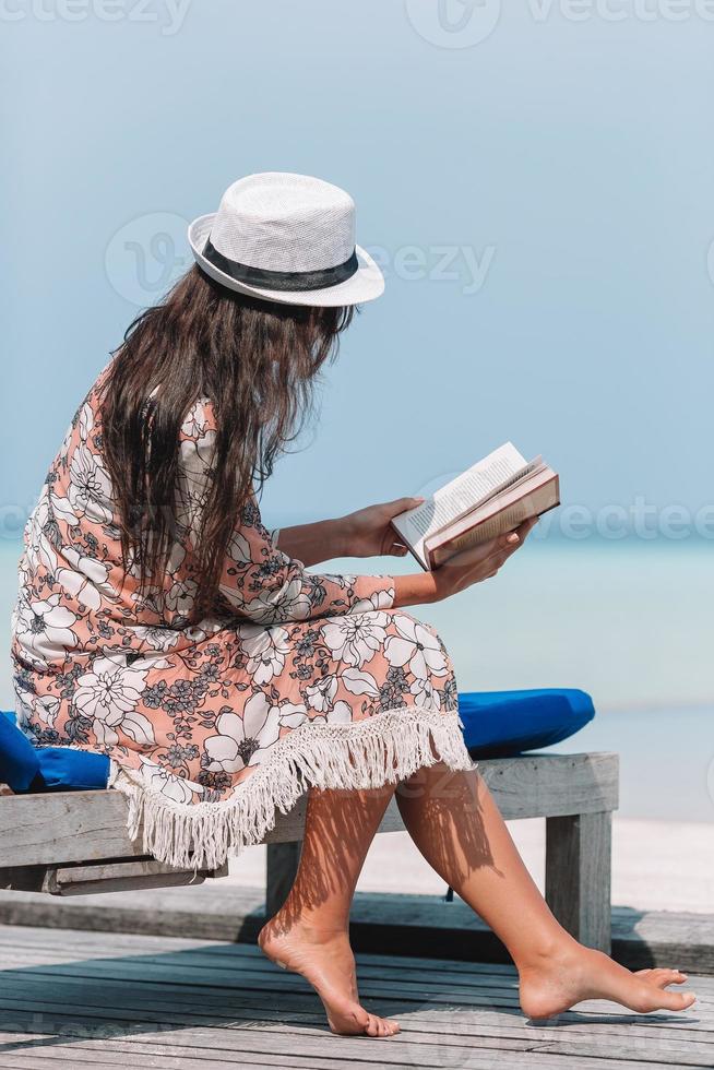 Lesebuch der jungen Frau während des tropischen maledivischen Strandes foto