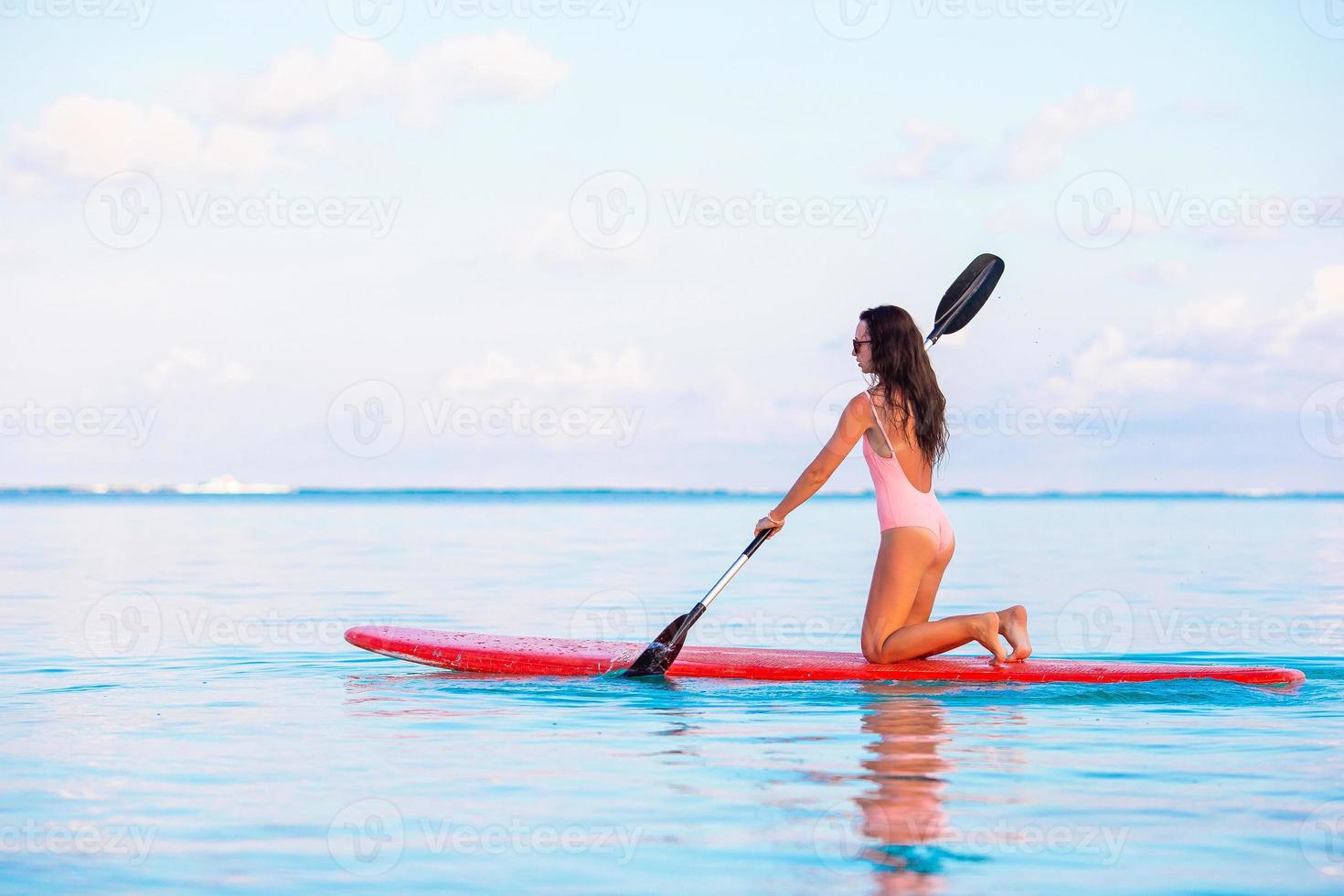 aktive junge Frau auf dem Stand Up Paddle Board foto