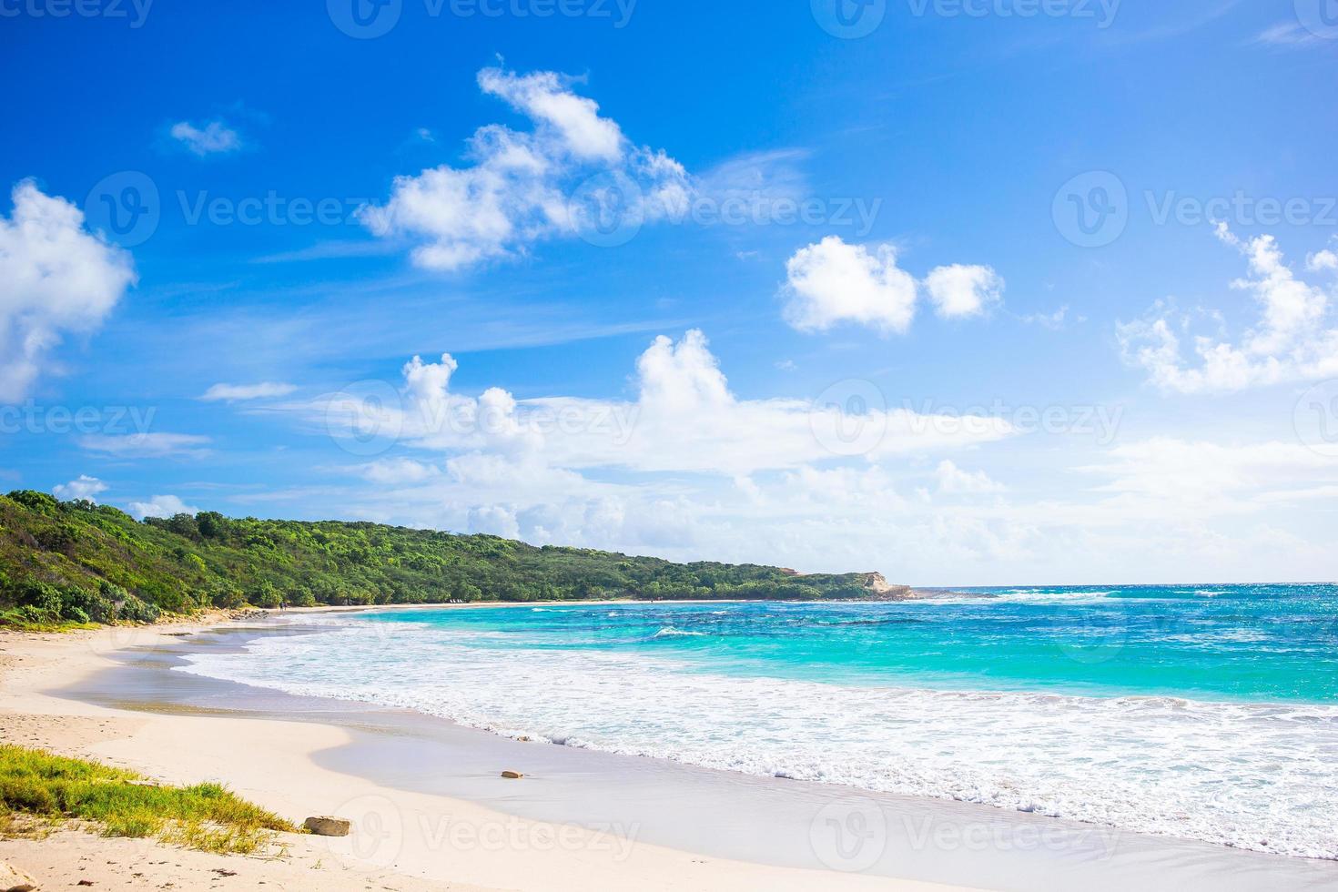 idyllischer tropischer strand in der karibik mit weißem sand, türkisfarbenem ozeanwasser und blauem himmel foto