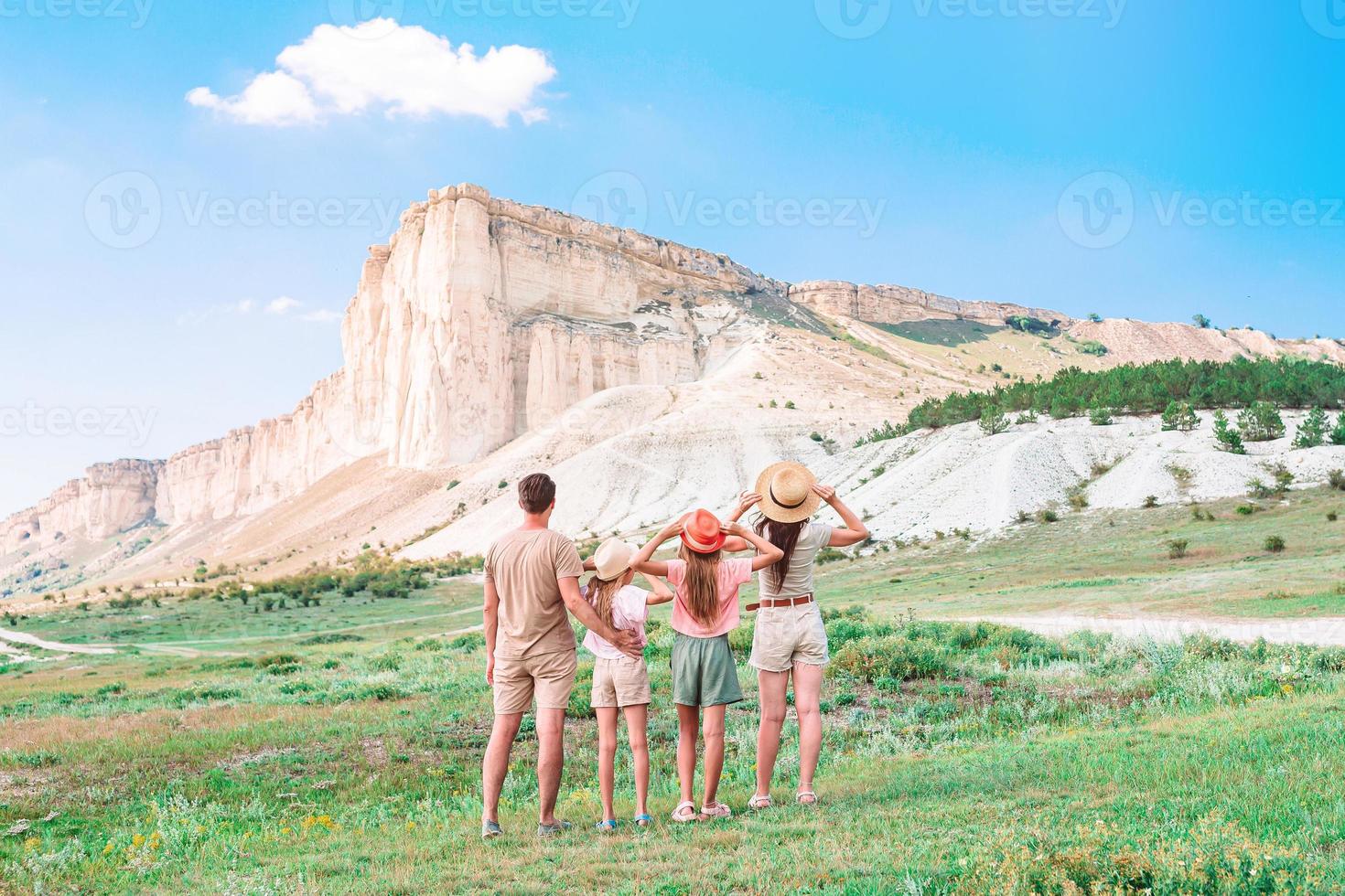 glückliche vierköpfige Familie beim Wandern in den Bergen foto