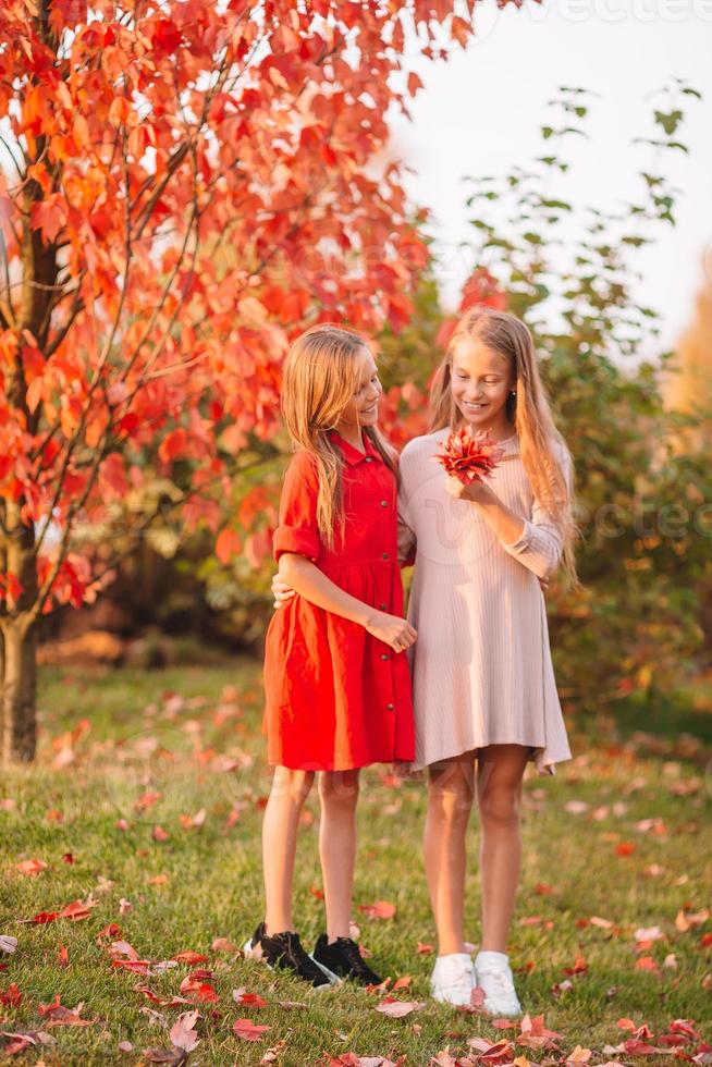 Kleine entzückende Mädchen im Freien am warmen, sonnigen Herbsttag foto