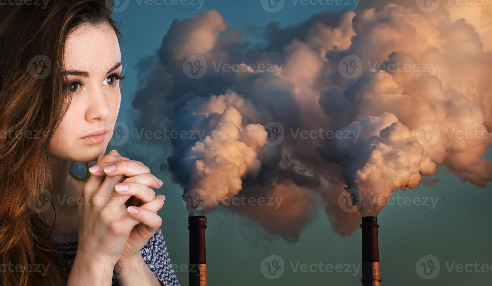 betende Frau gegen Rohre, die eine Atmosphäre verschmutzen foto