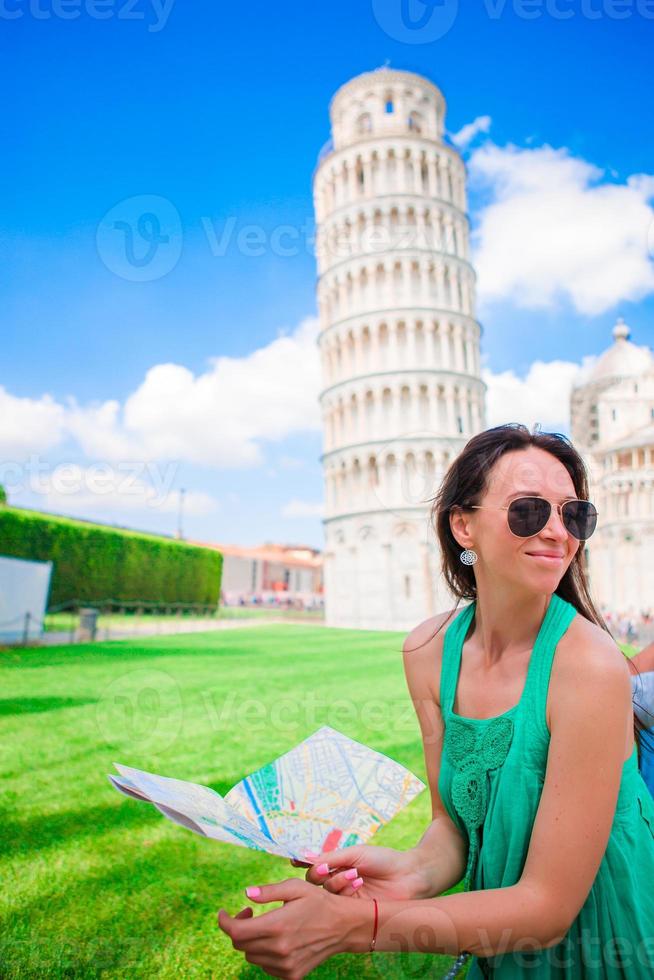 junges glückliches mädchen mit toristischer karte auf reise nach pisa. reisender tourist, der den schiefen turm von pisa besucht. foto