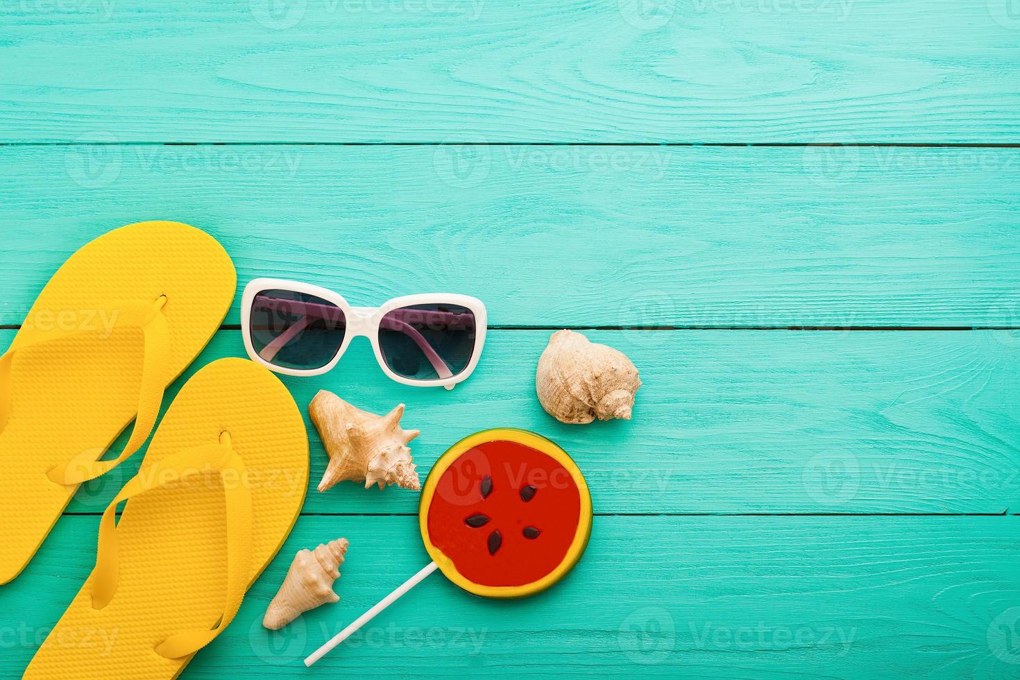 Sommer Accessoires. Flip Flops, Sonnenbrille, Handtuch, rote Mütze und Orangen auf blauem Holzhintergrund. Platz kopieren. foto